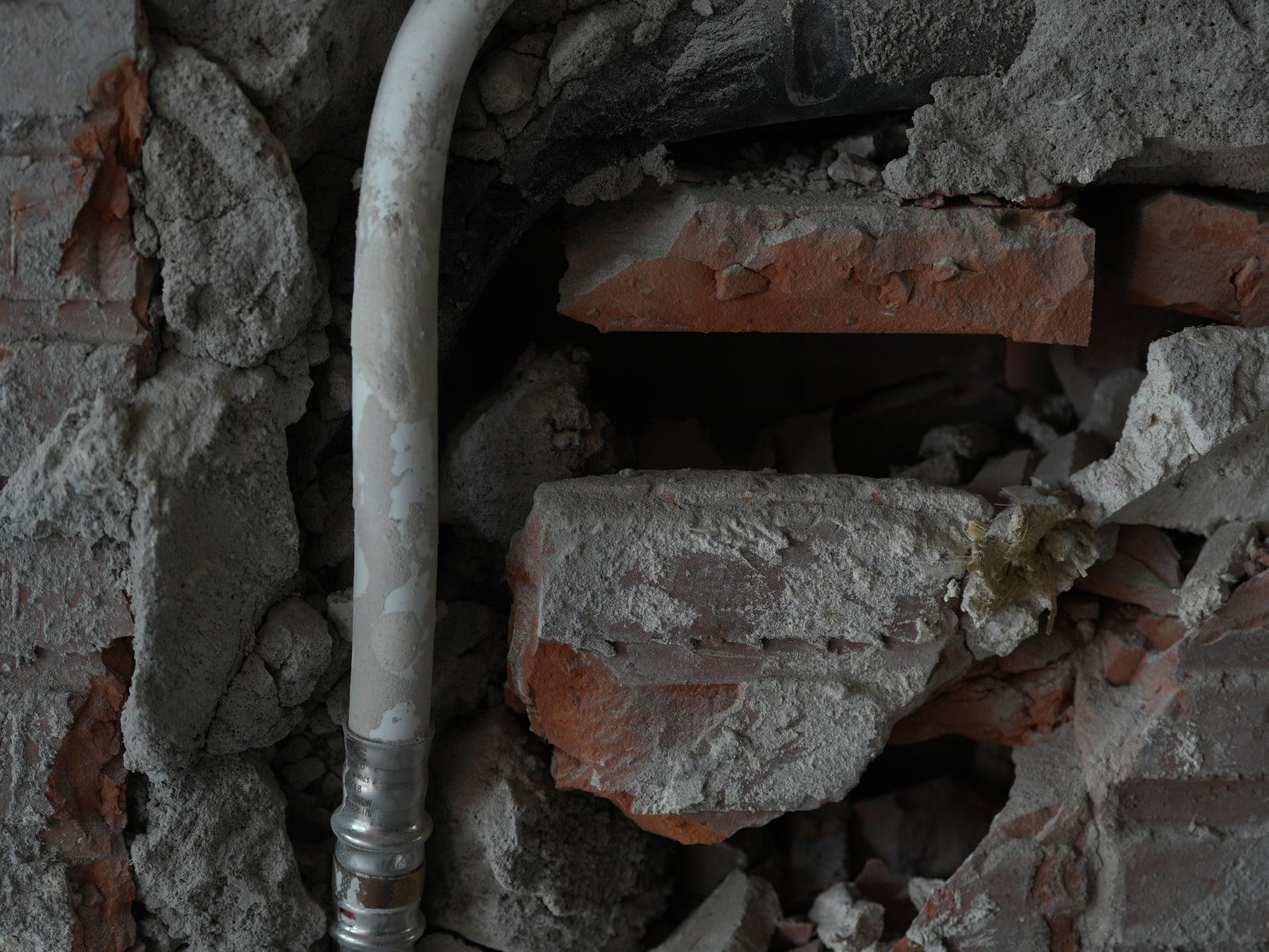 Exposed brick and services pipe — material traces
