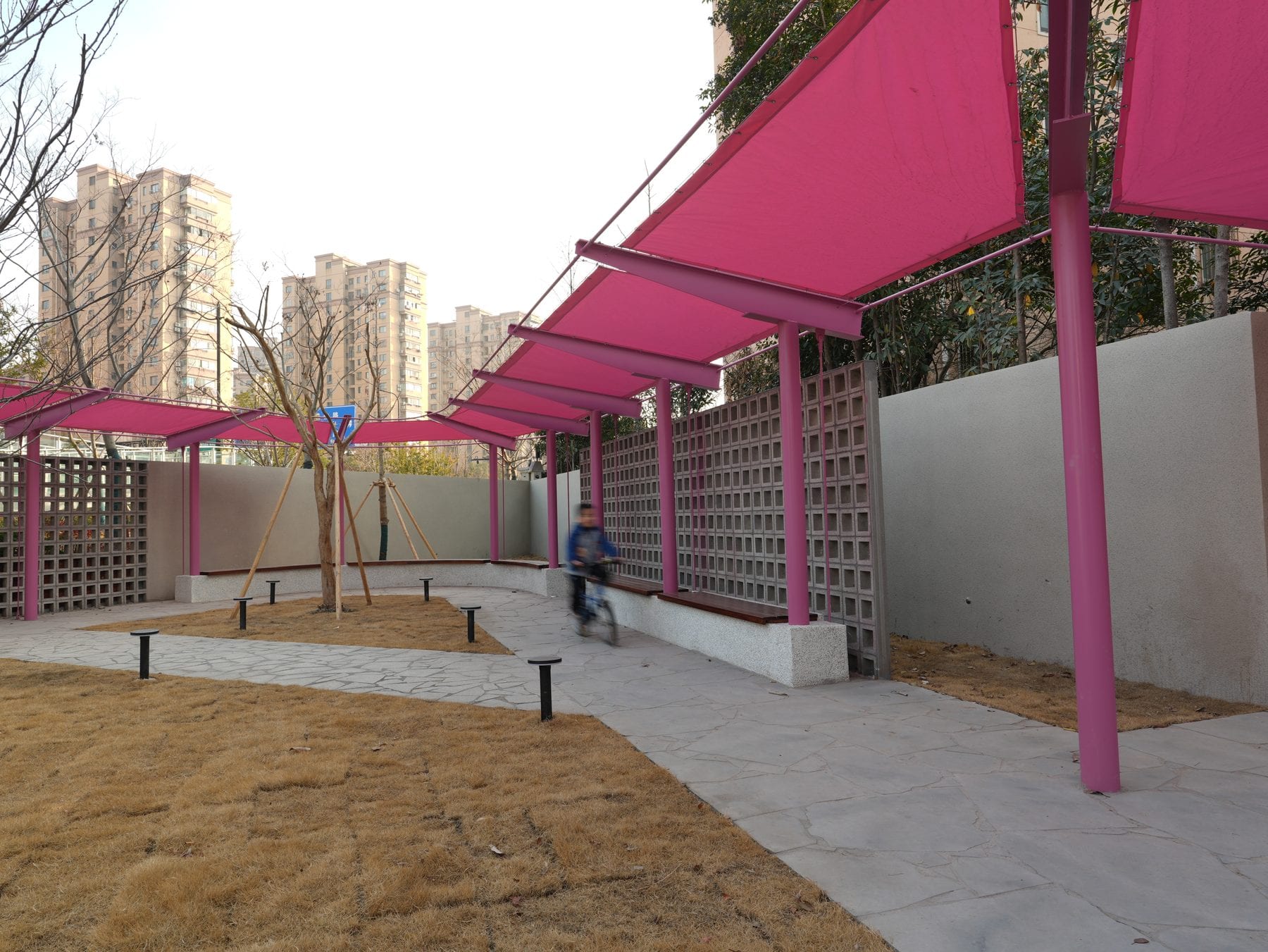 The pergola row against the residential towers