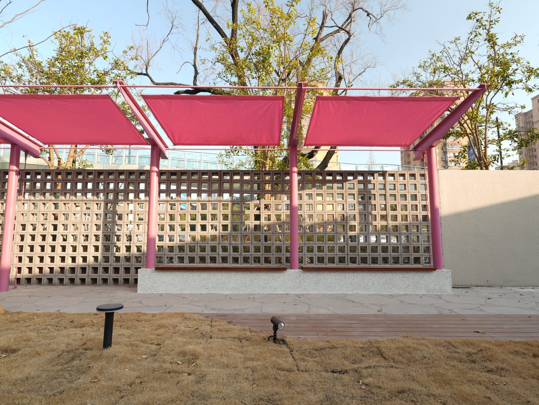 Breeze-block screen wall beneath the pink canopy