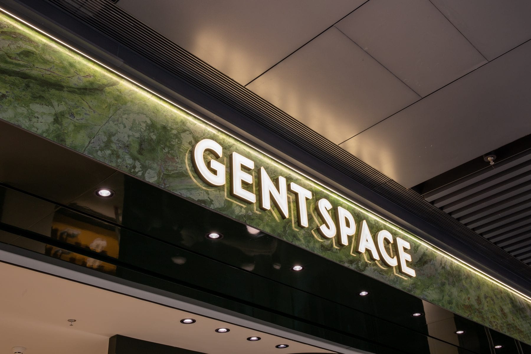 The illuminated GENTSPACE sign on green marble