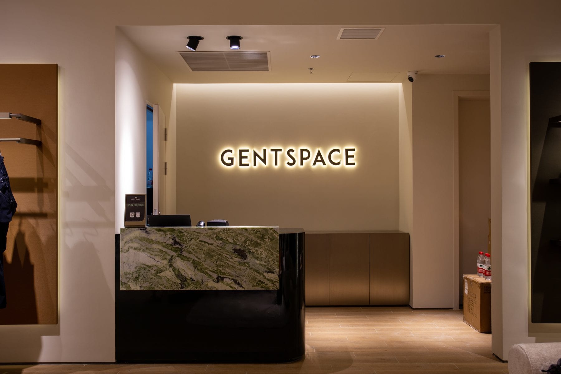 Backlit logo wall above the stone cashier counter