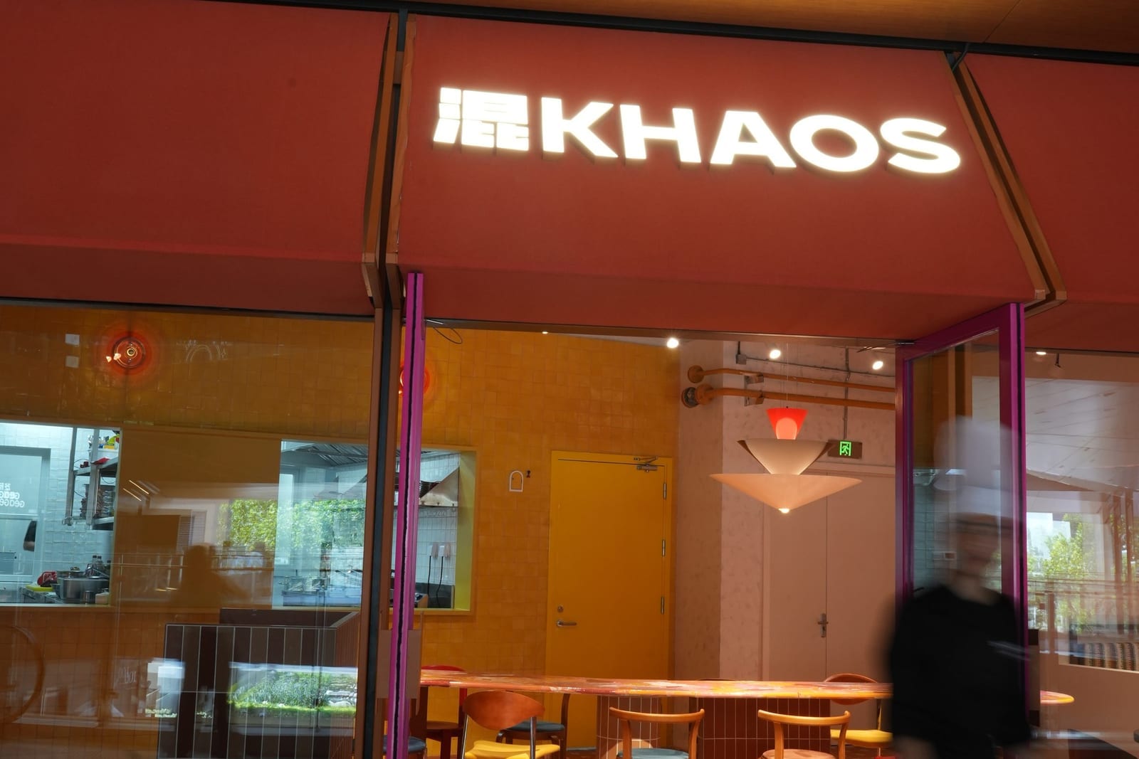 The 混KHAOS storefront with illuminated sign at dusk