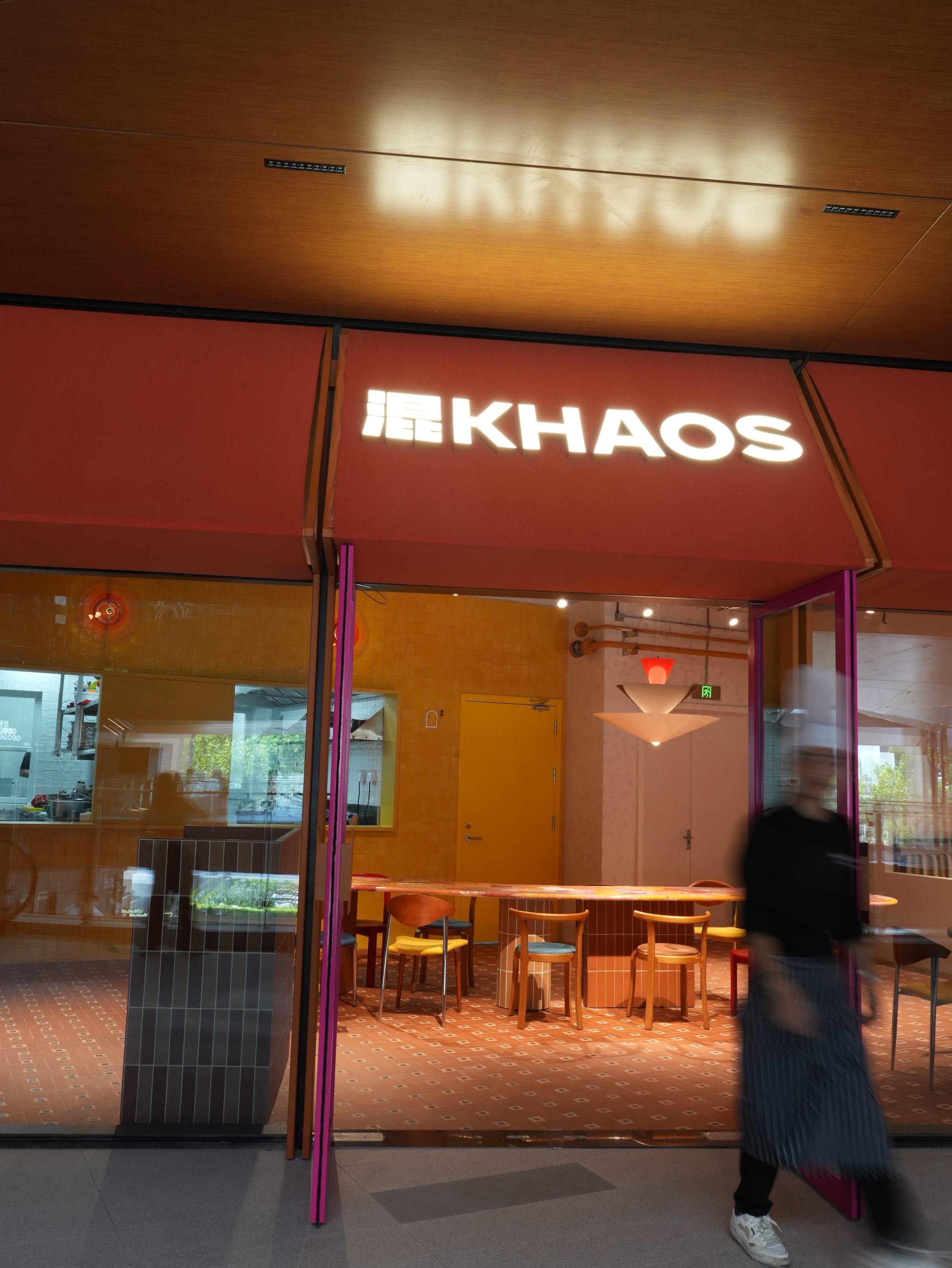 The 混KHAOS storefront with illuminated sign at dusk