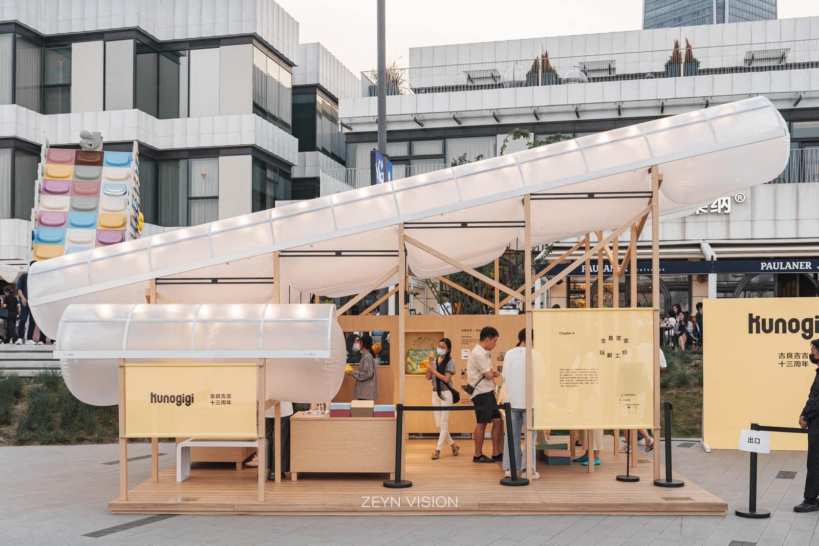 Front view with KUNOGIGI signage and yellow kiosk modules