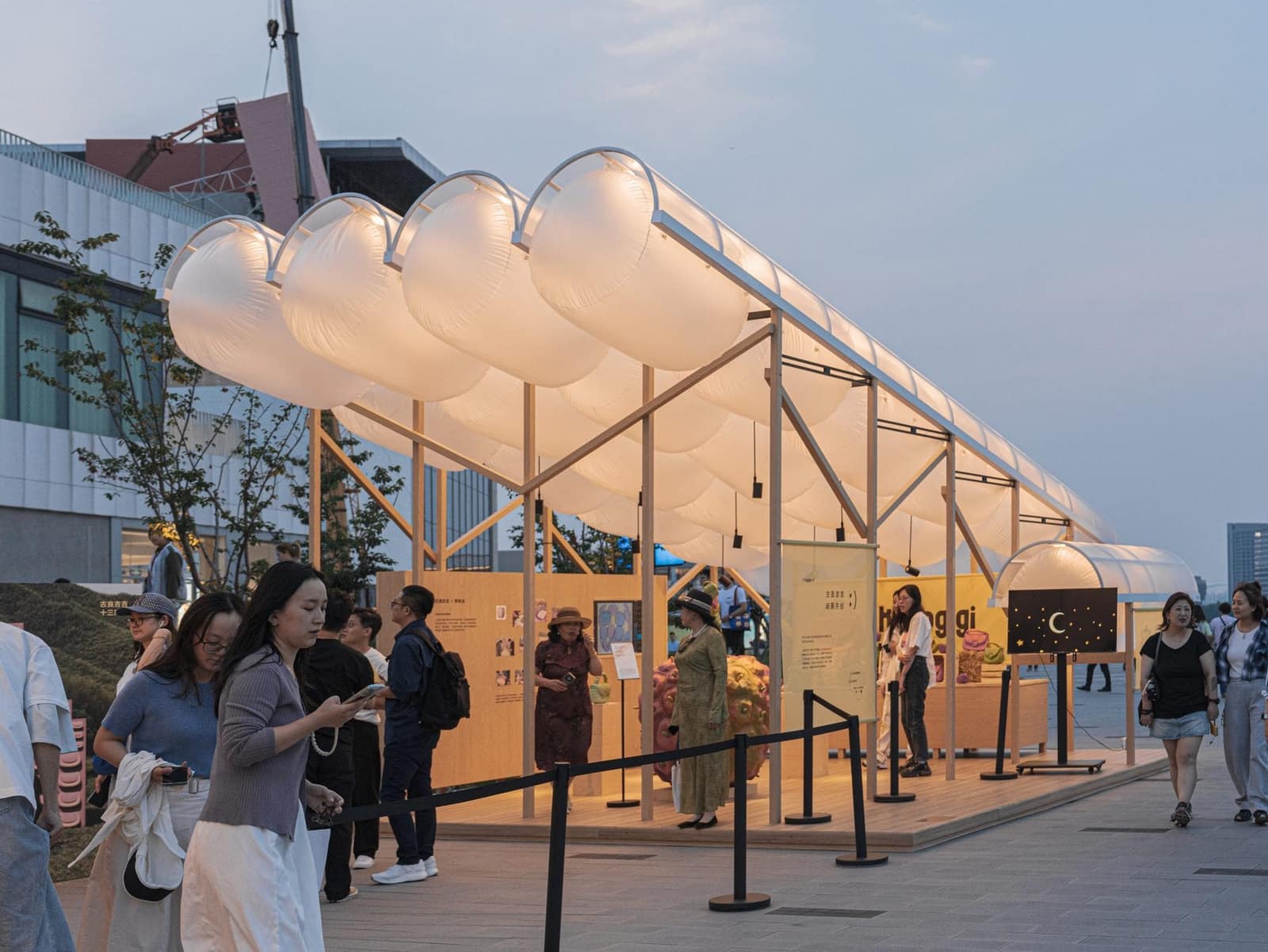 Visitors queueing under the glowing canopy at dusk
