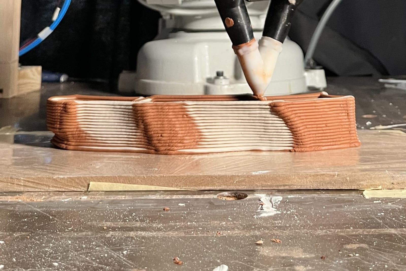 Robotic arm depositing mortar in the multi-material printing process