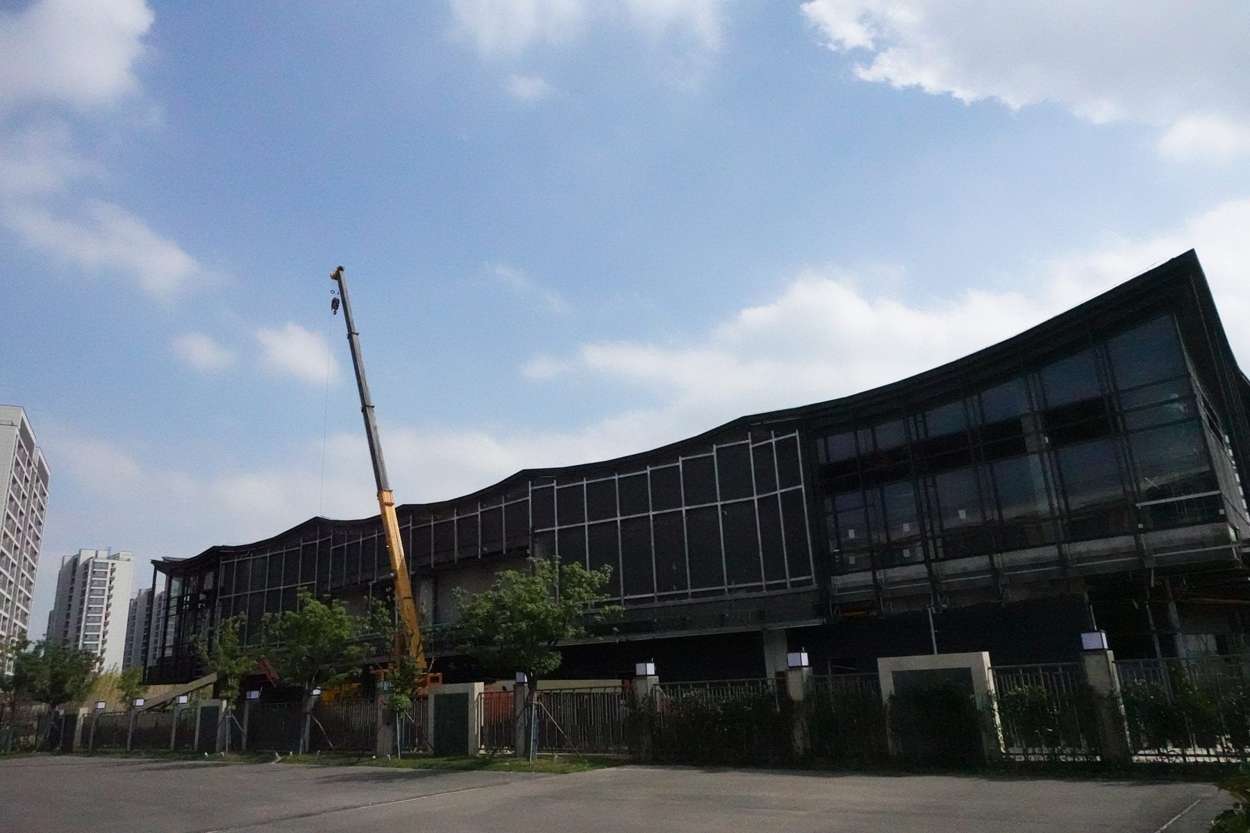 The granary block at Panlong Tiandi — sweeping roof over full-height glazing, facade nearing completion