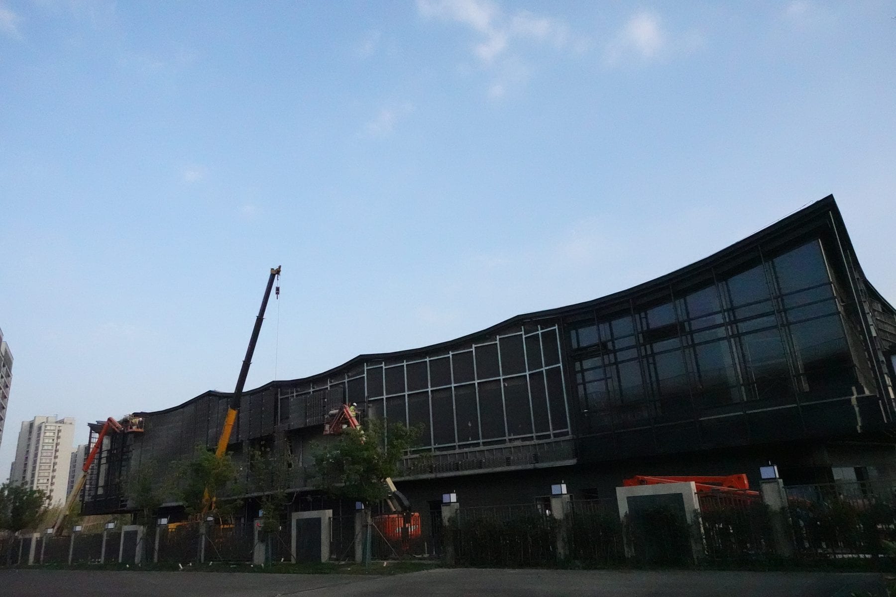 Late-afternoon survey of the completed facade bays and entry sequence