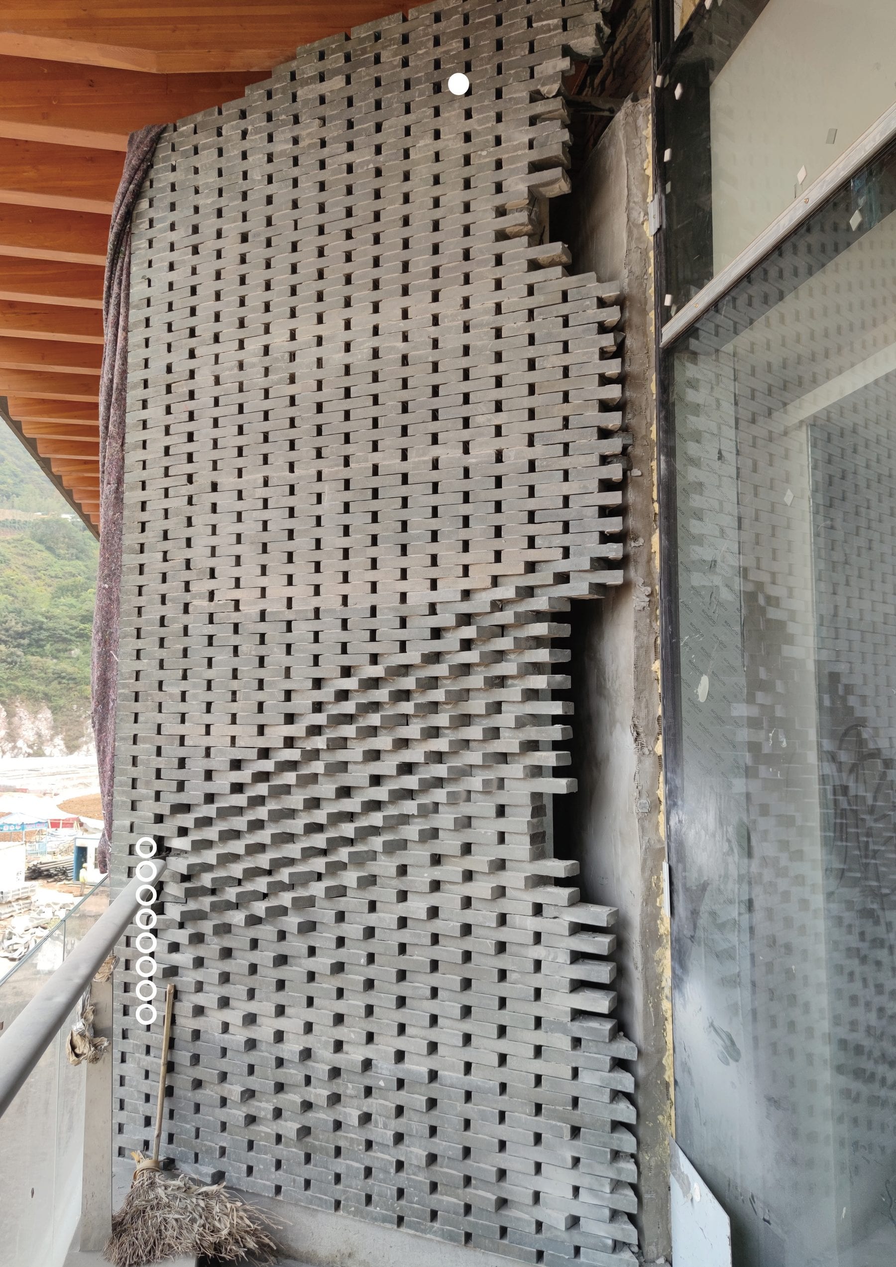 Installed perforated brick screen panel with tagged bricks awaiting adjustment, south tower