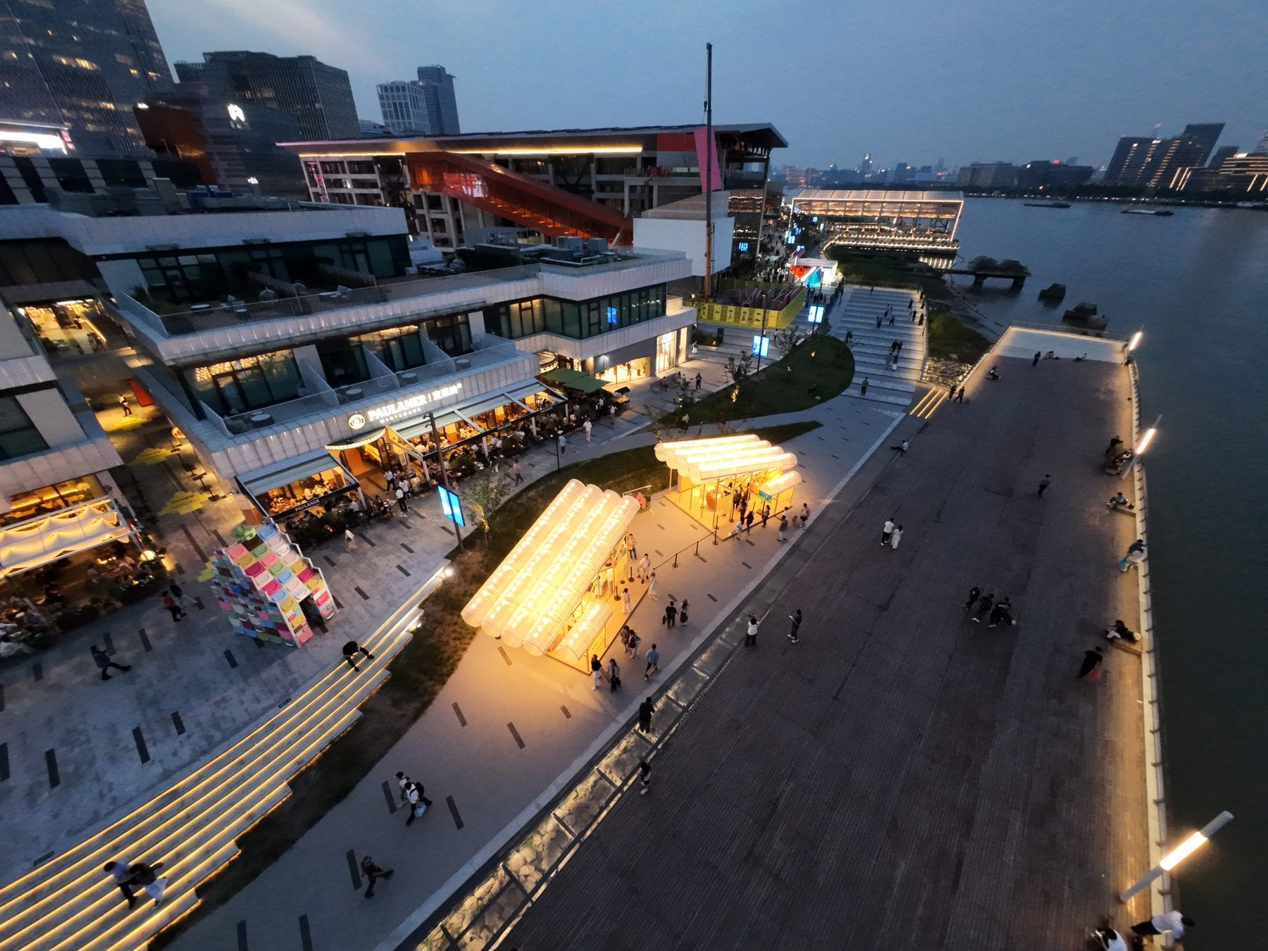 Drone view of the pavilion pair at dusk along the riverfront