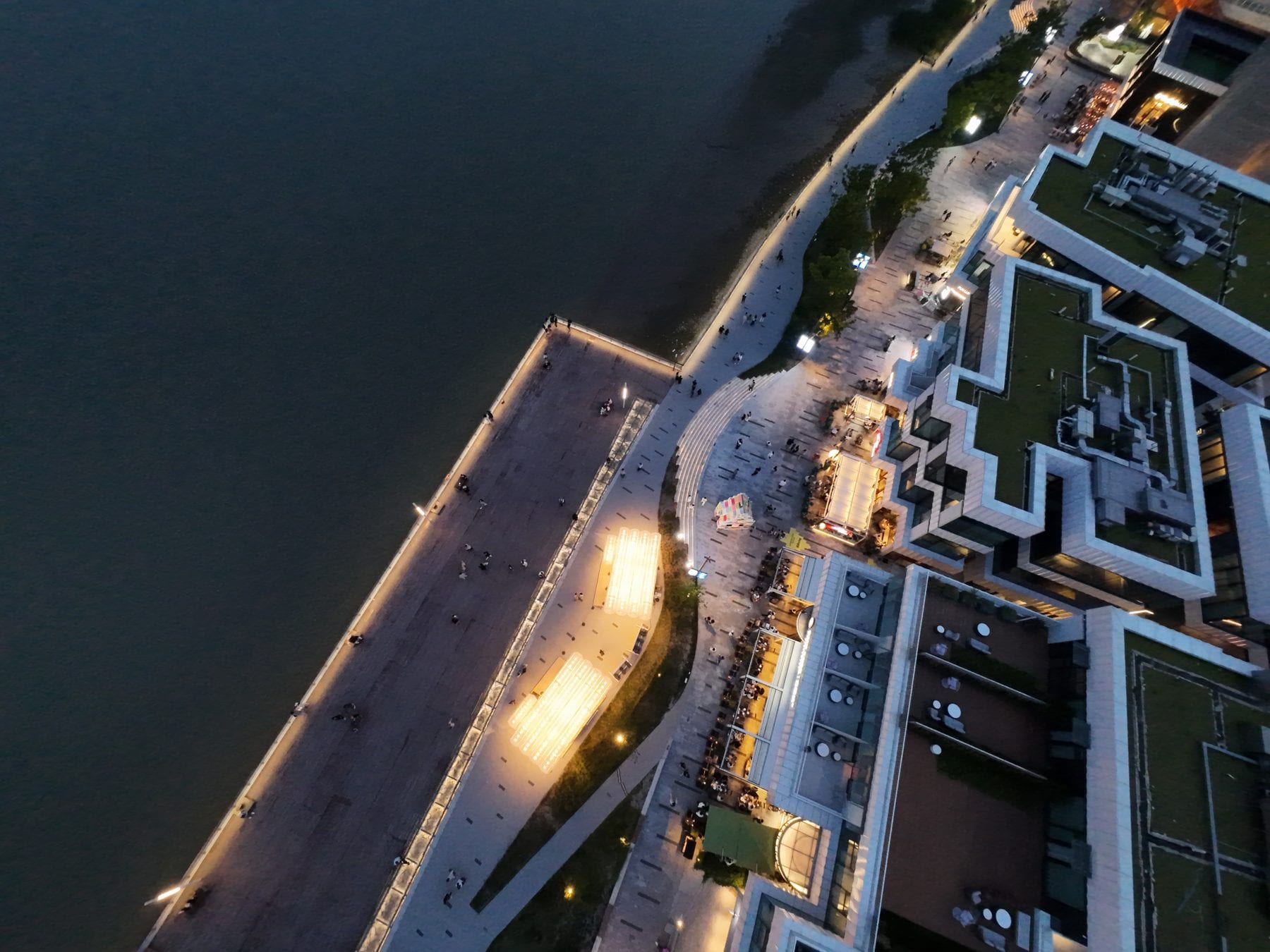Top-down night drone view of the two glowing canopies
