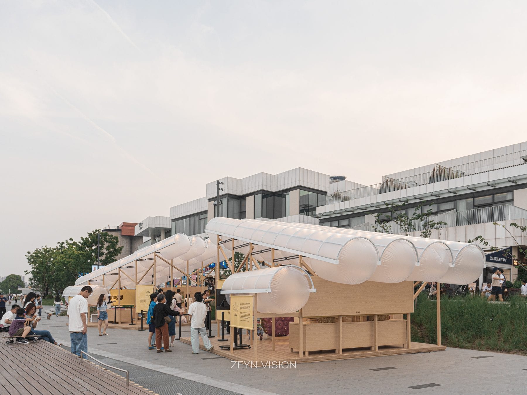 Side view of the timber kiosks under the white tube canopy