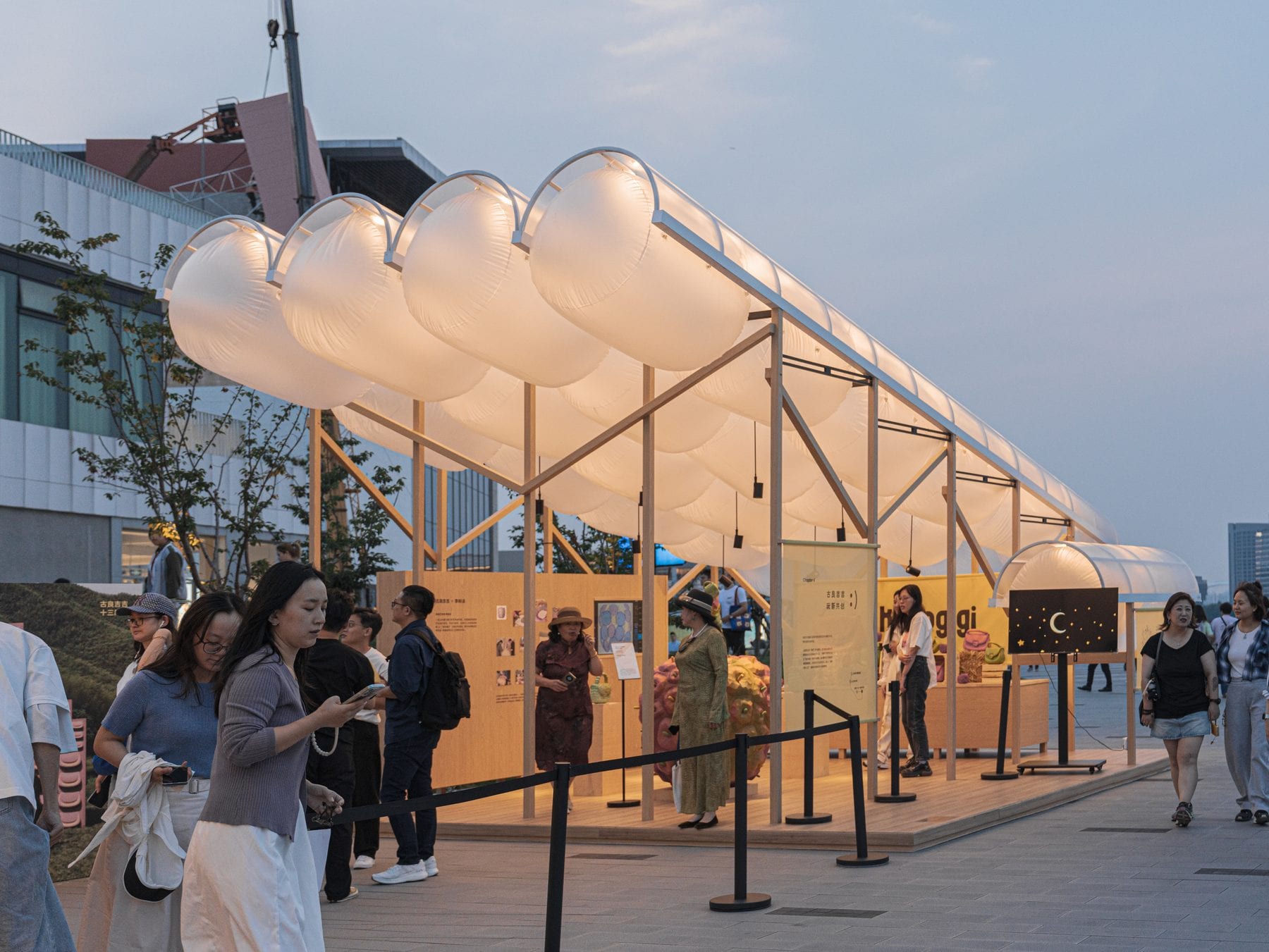 Visitors queueing under the glowing canopy at dusk