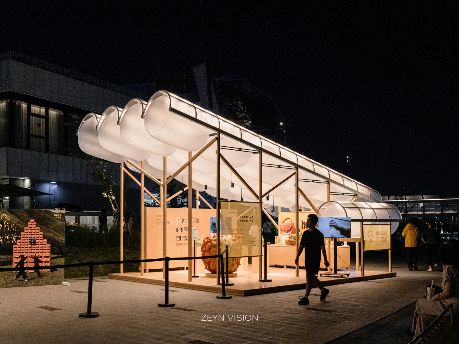 A single glowing pavilion against the night plaza
