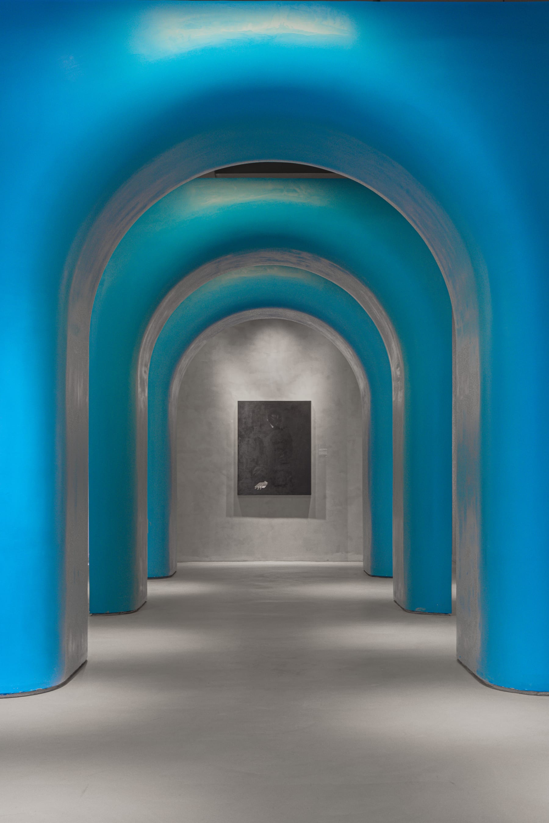 Blue arched corridor, empty, leading to a dark painting