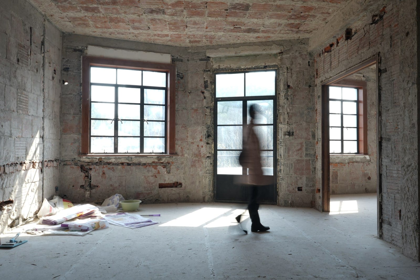Figure walking through the vaulted brick room of Meiqi Apartments