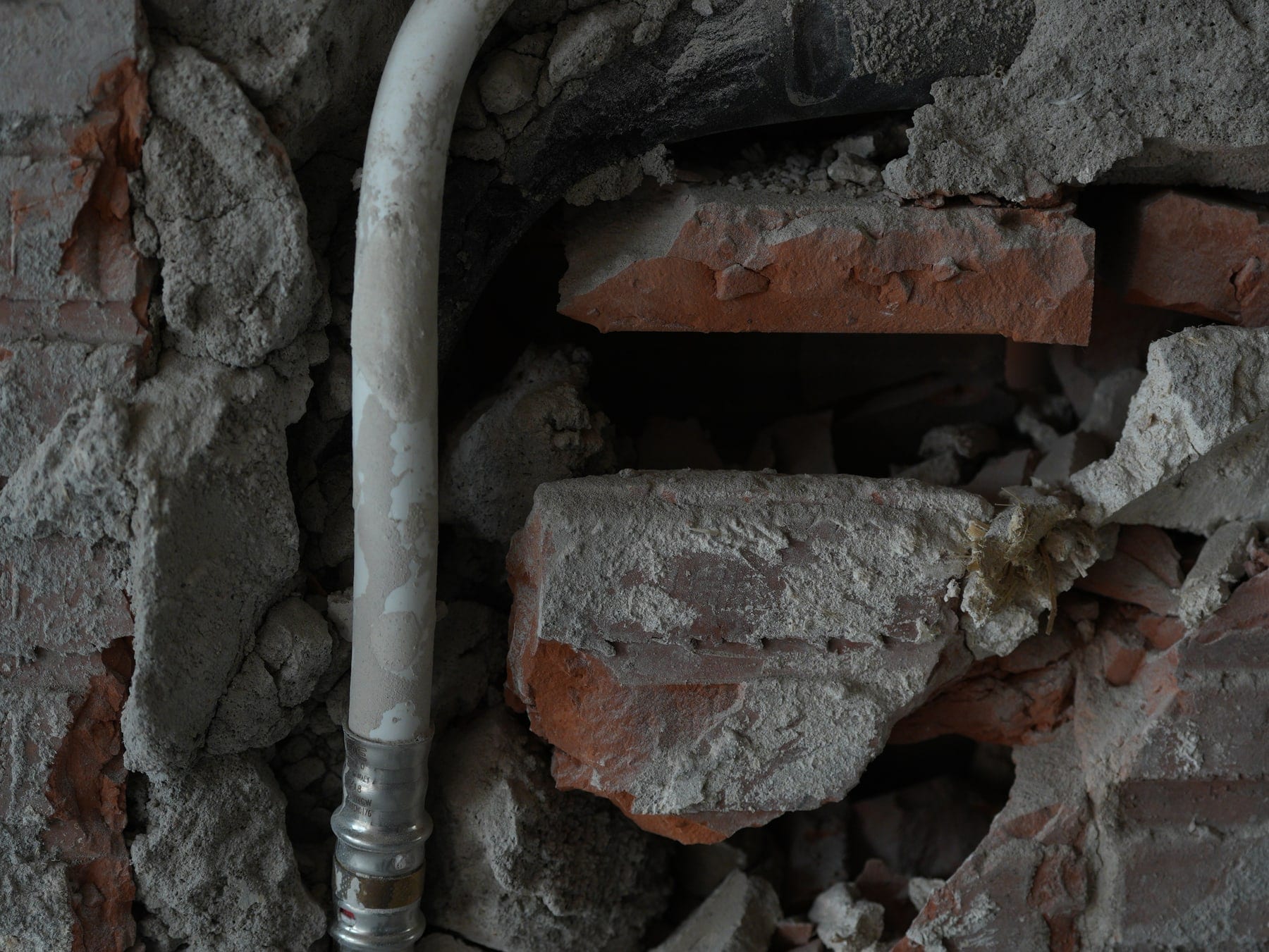 Exposed brick and services pipe — material traces