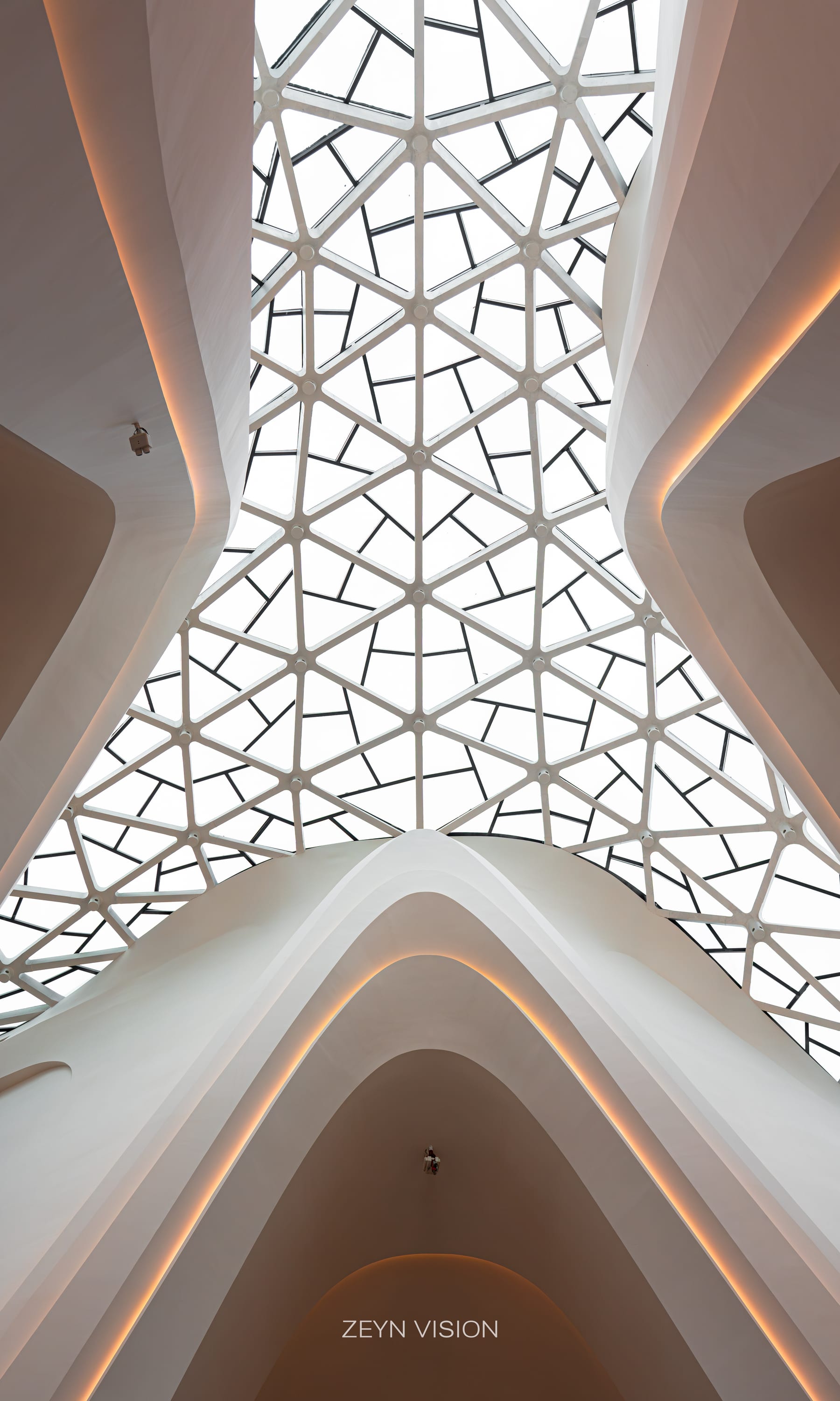 The glazed diagrid skylight over flowing white interior forms