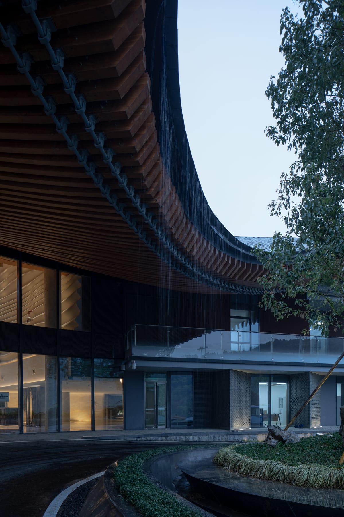Curved roof and glass facade at dusk