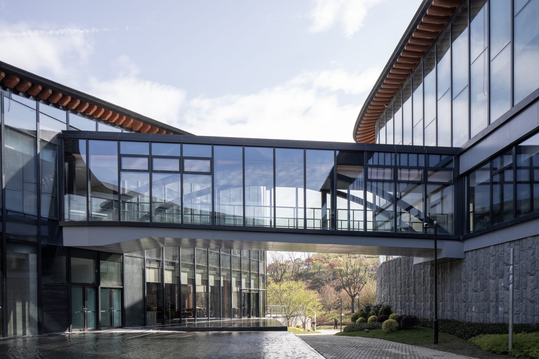 Glass link bridge between the curved wings