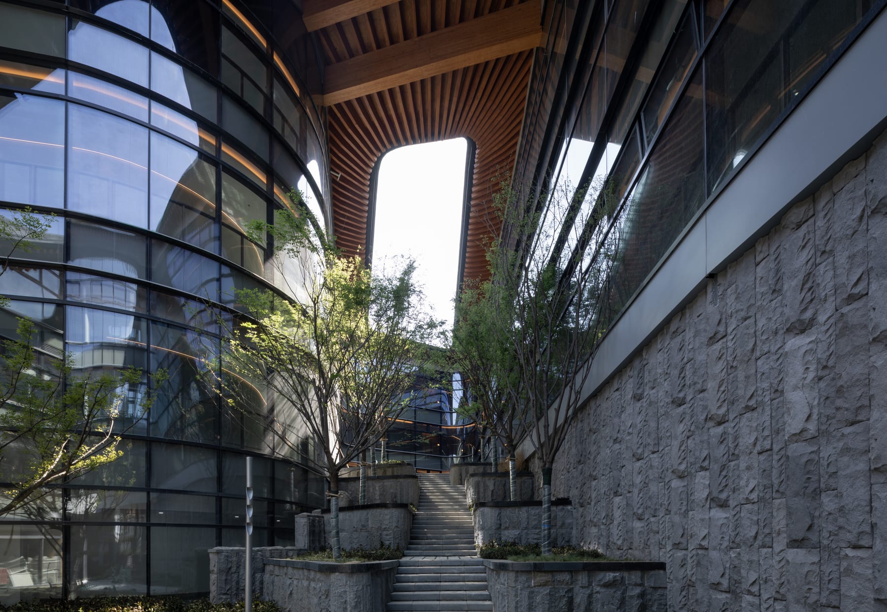 Stone-walled courtyard against the glass facade
