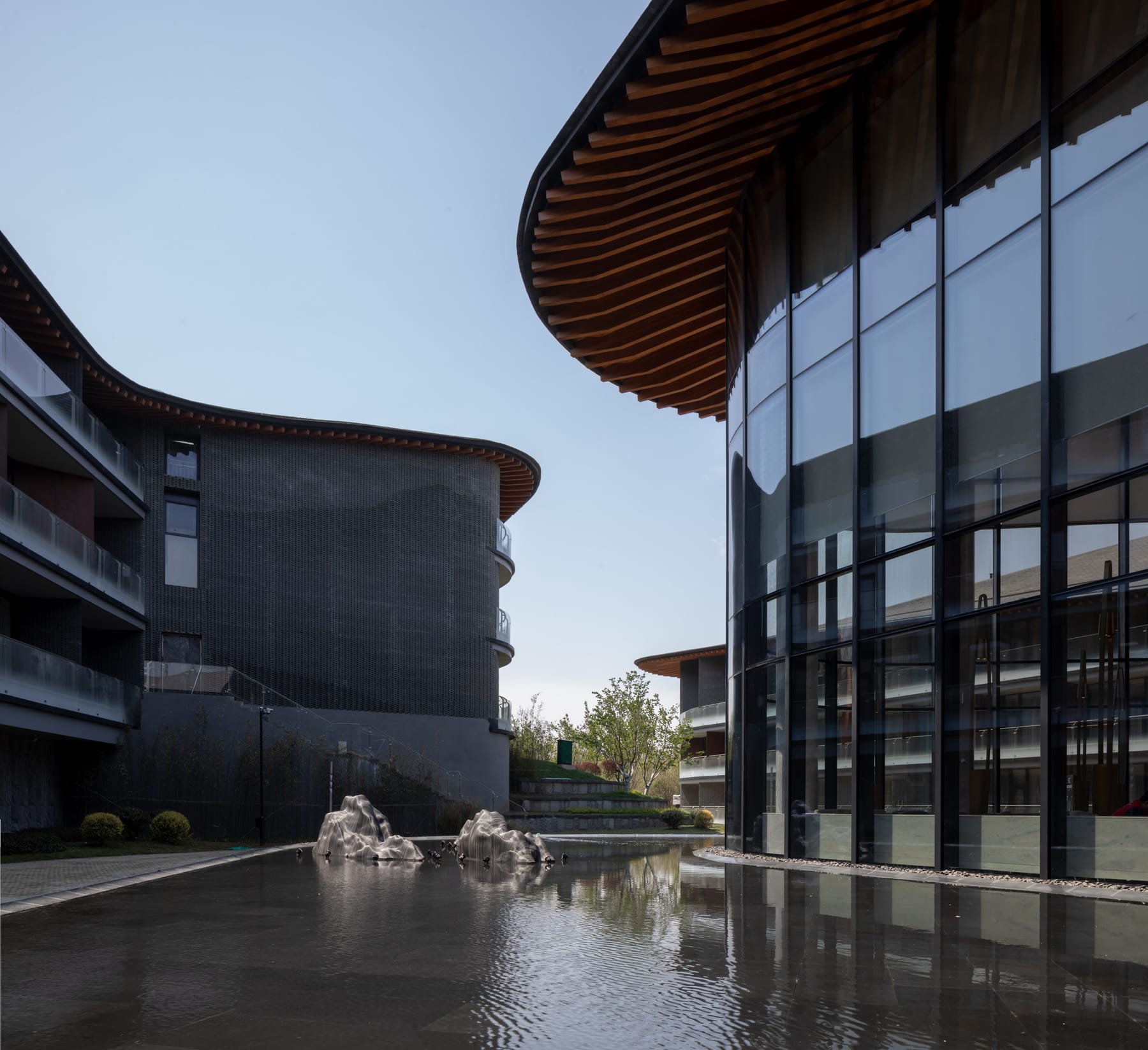 Curved roofs reflected in the water courtyard
