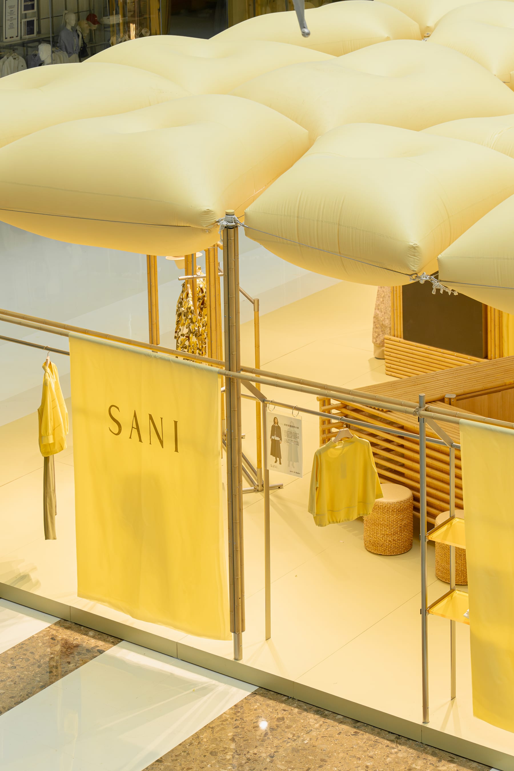 Daylight from the mall skylight — SANI fabric wall and pillow canopy seen from the upper floor
