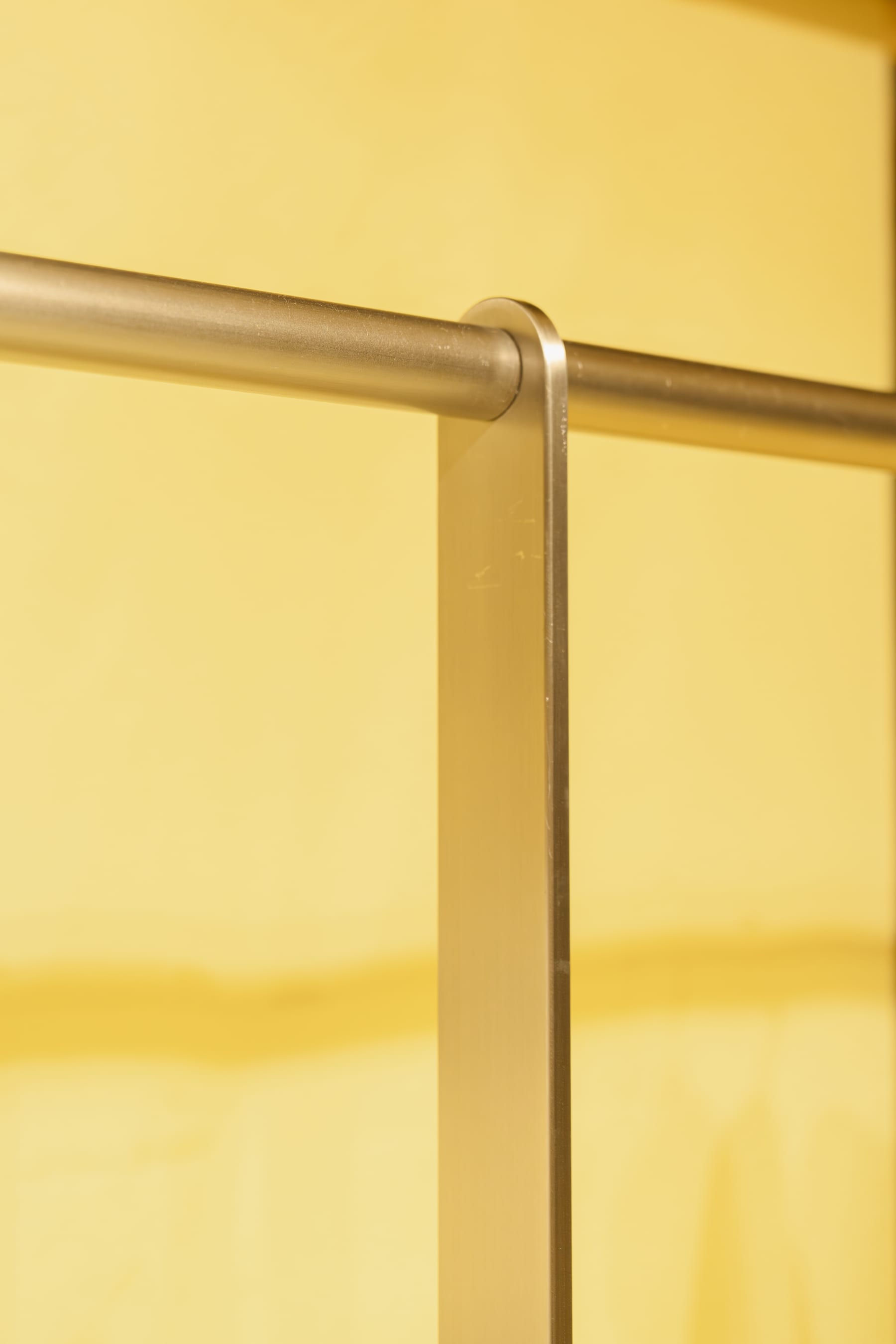 T-junction of the steel hanging rods against yellow fabric