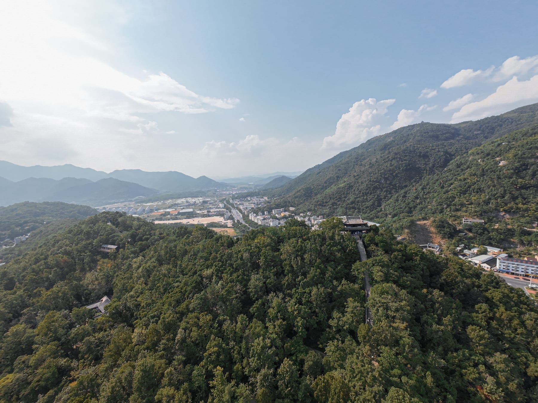 Layered forested ridges above a Taizhou valley town