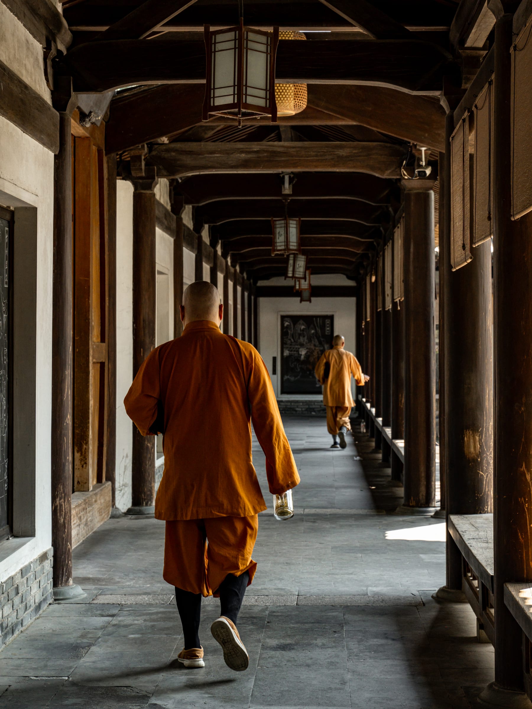 Monks crossing the wooden corridor of the temple