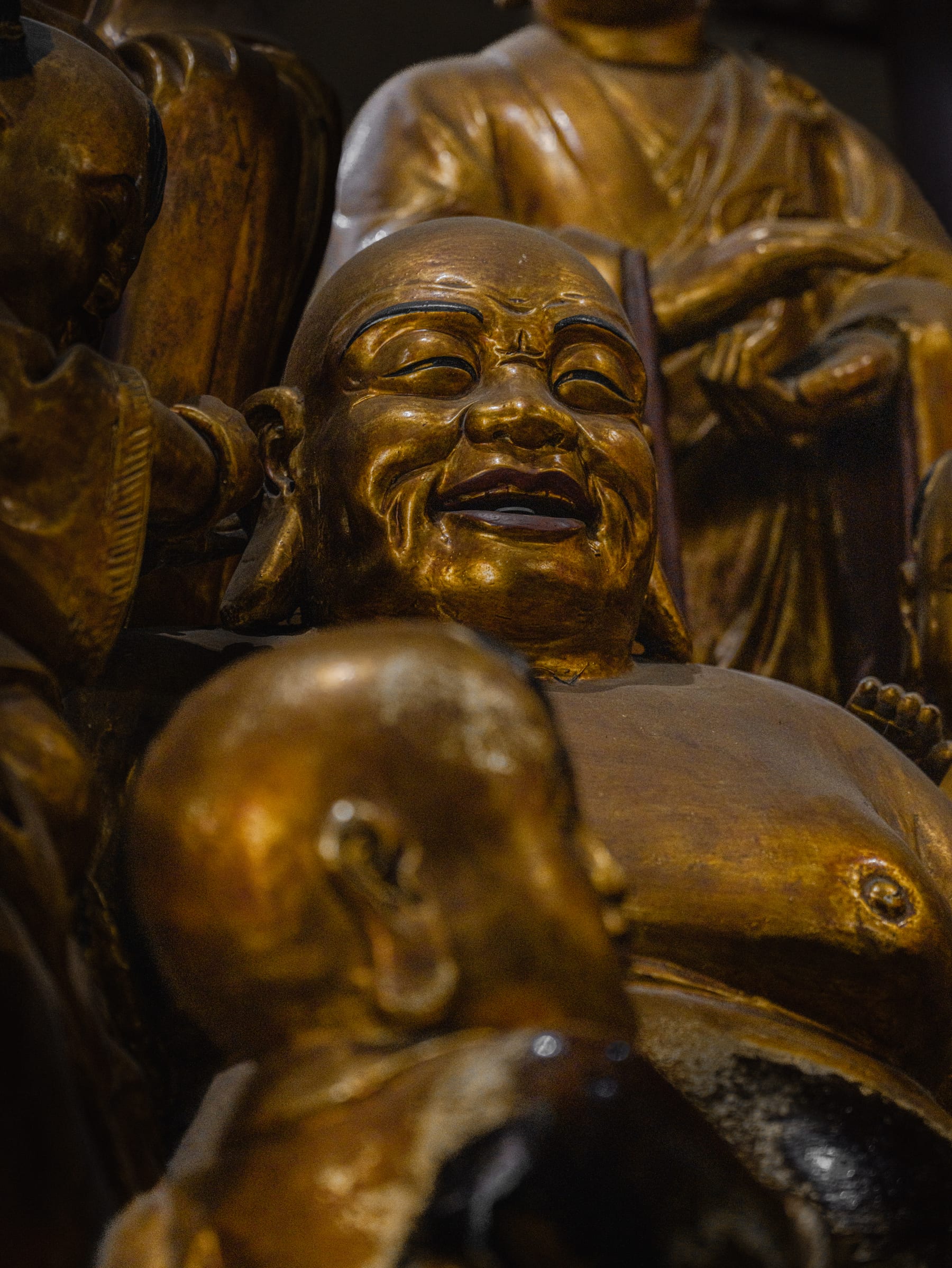 Golden luohan statues crowded in the dark hall