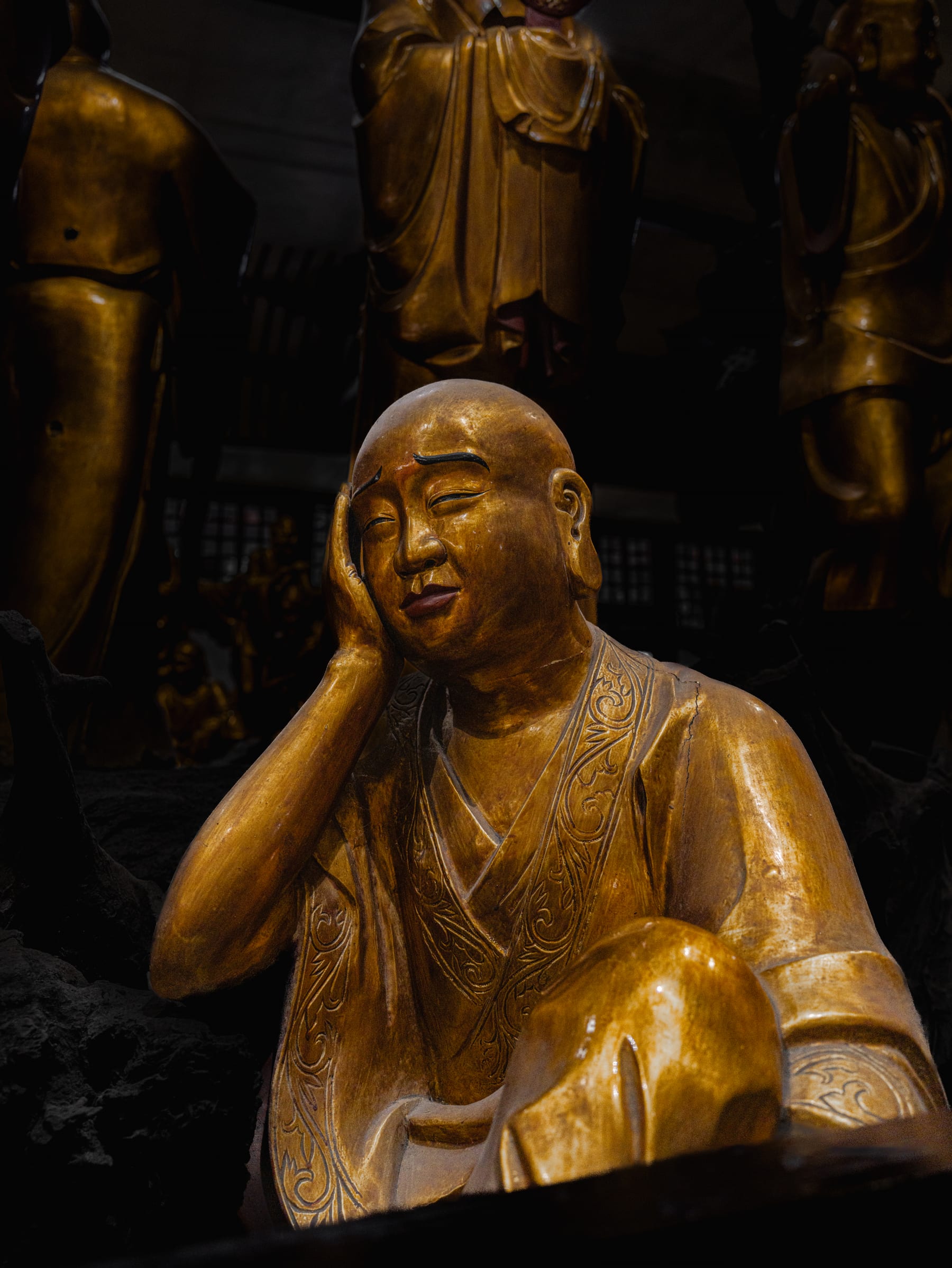 A seated golden luohan in quiet light