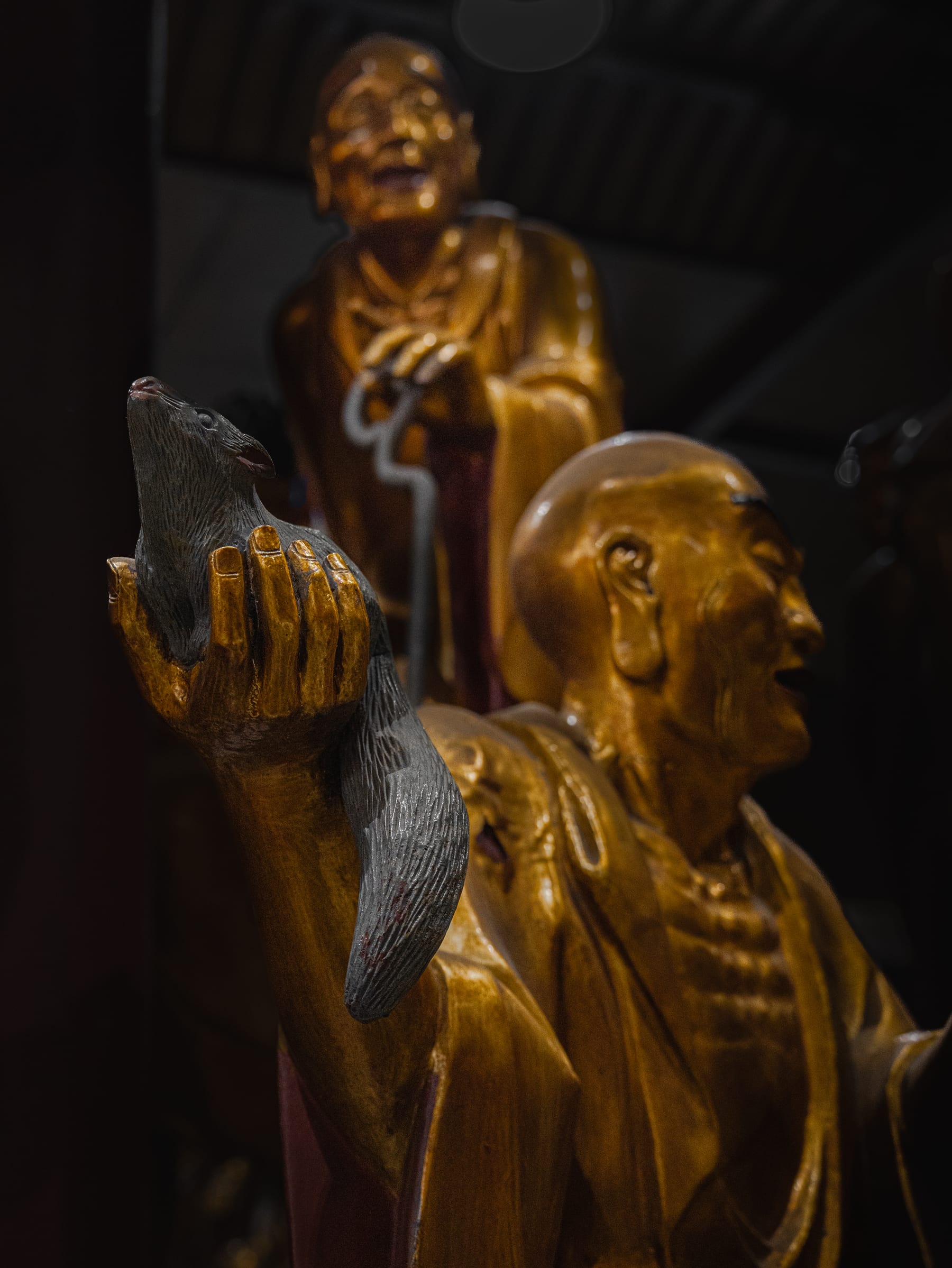 Luohan statue holding a small creature, detail