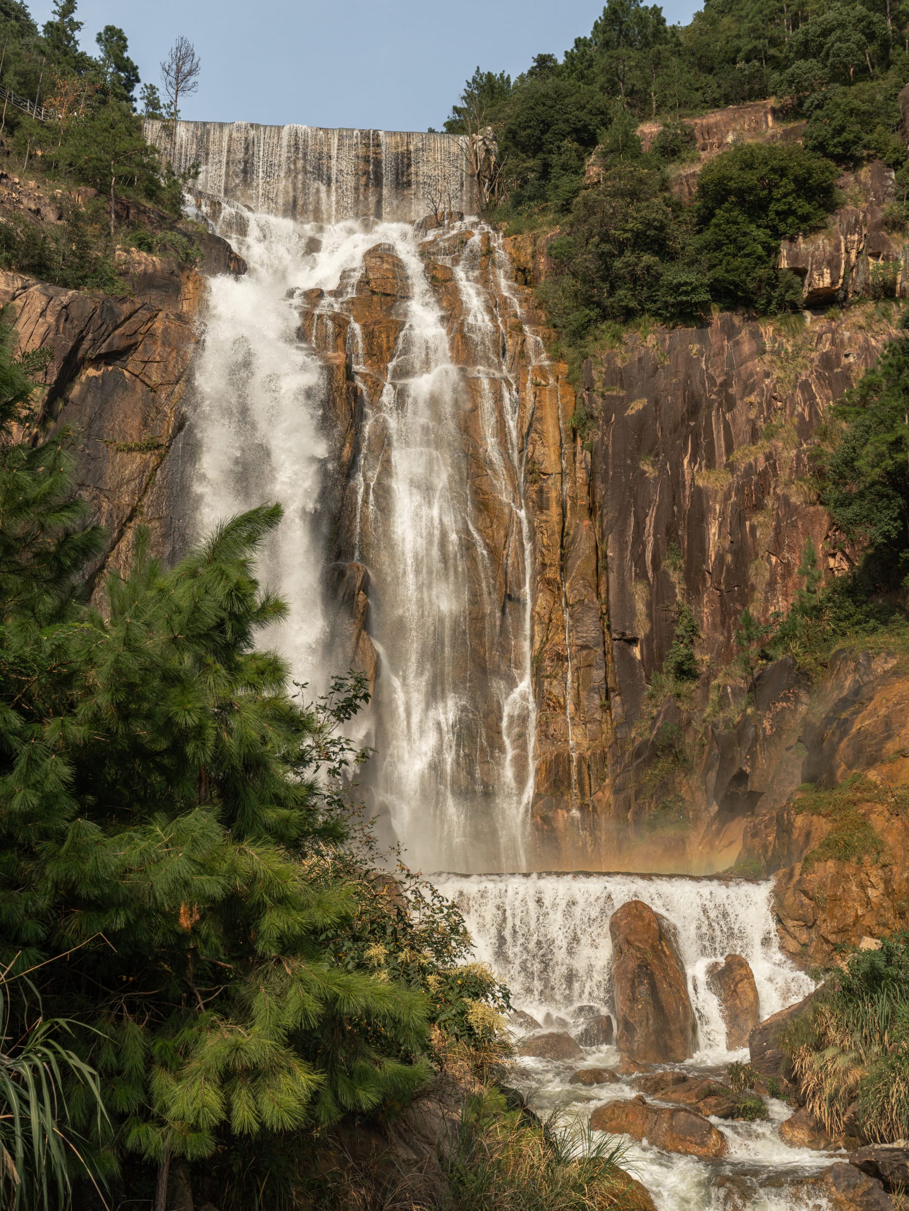 The grand waterfall pouring over the ochre cliff
