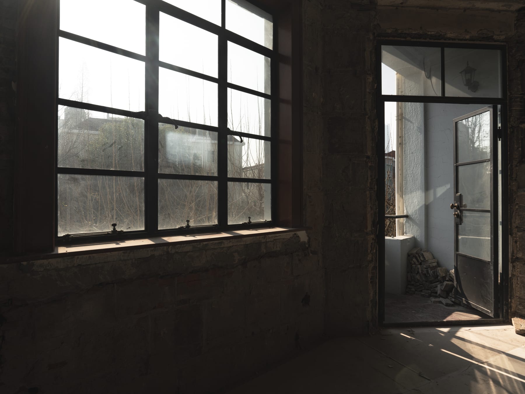 Steel-frame window and glass door in the raw apartment