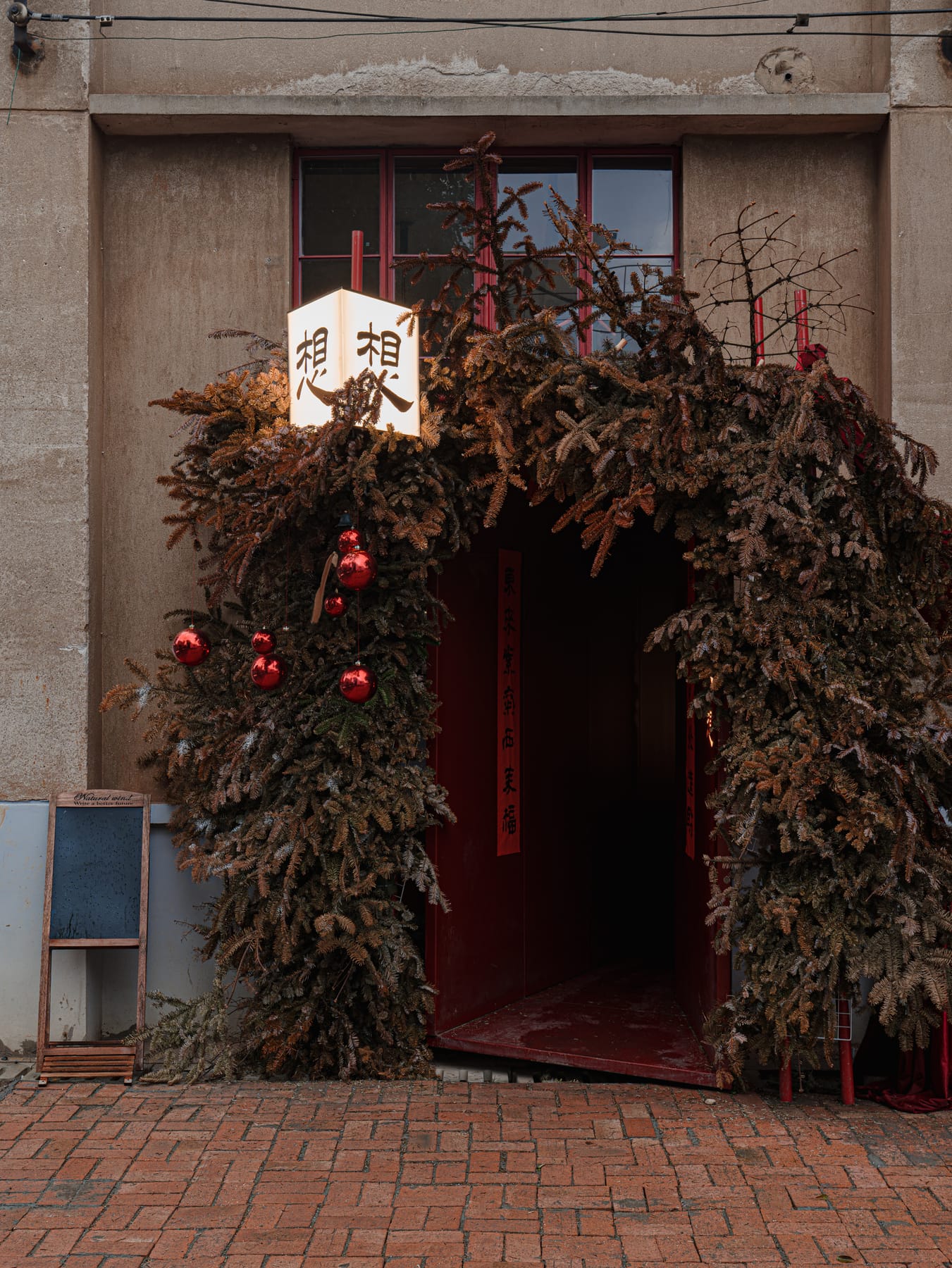Wreath-wrapped entrance door with the cafe's lantern