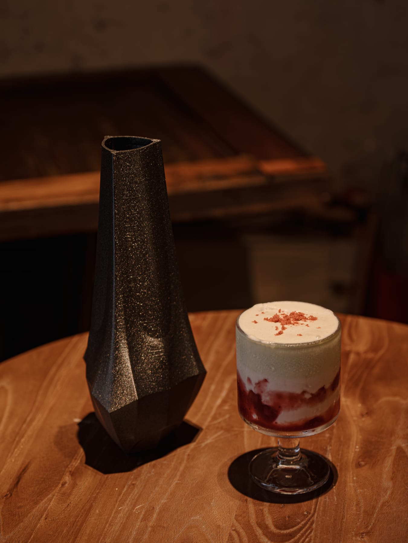 Coffee and a black vase on the wooden table
