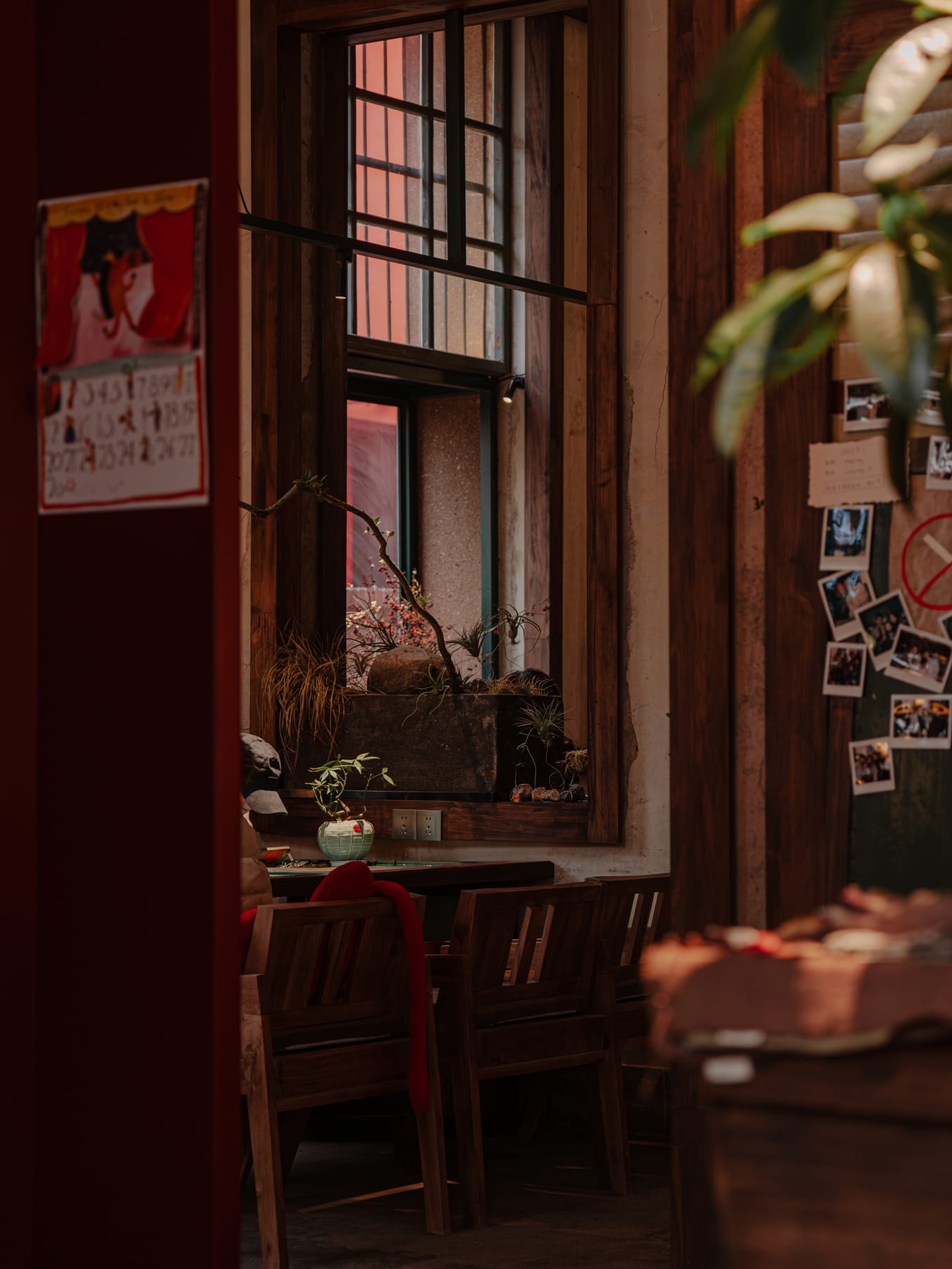 Seating by the window, polaroids on the wall